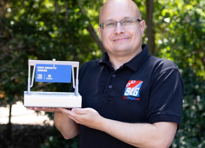 Adam from Safety Liftin Gear shows off the High Growth Award we received at Reid Lifting's 30-year anniversary event